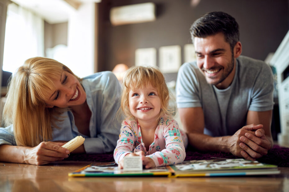 Little girl playing with a puzzle book with her parents.